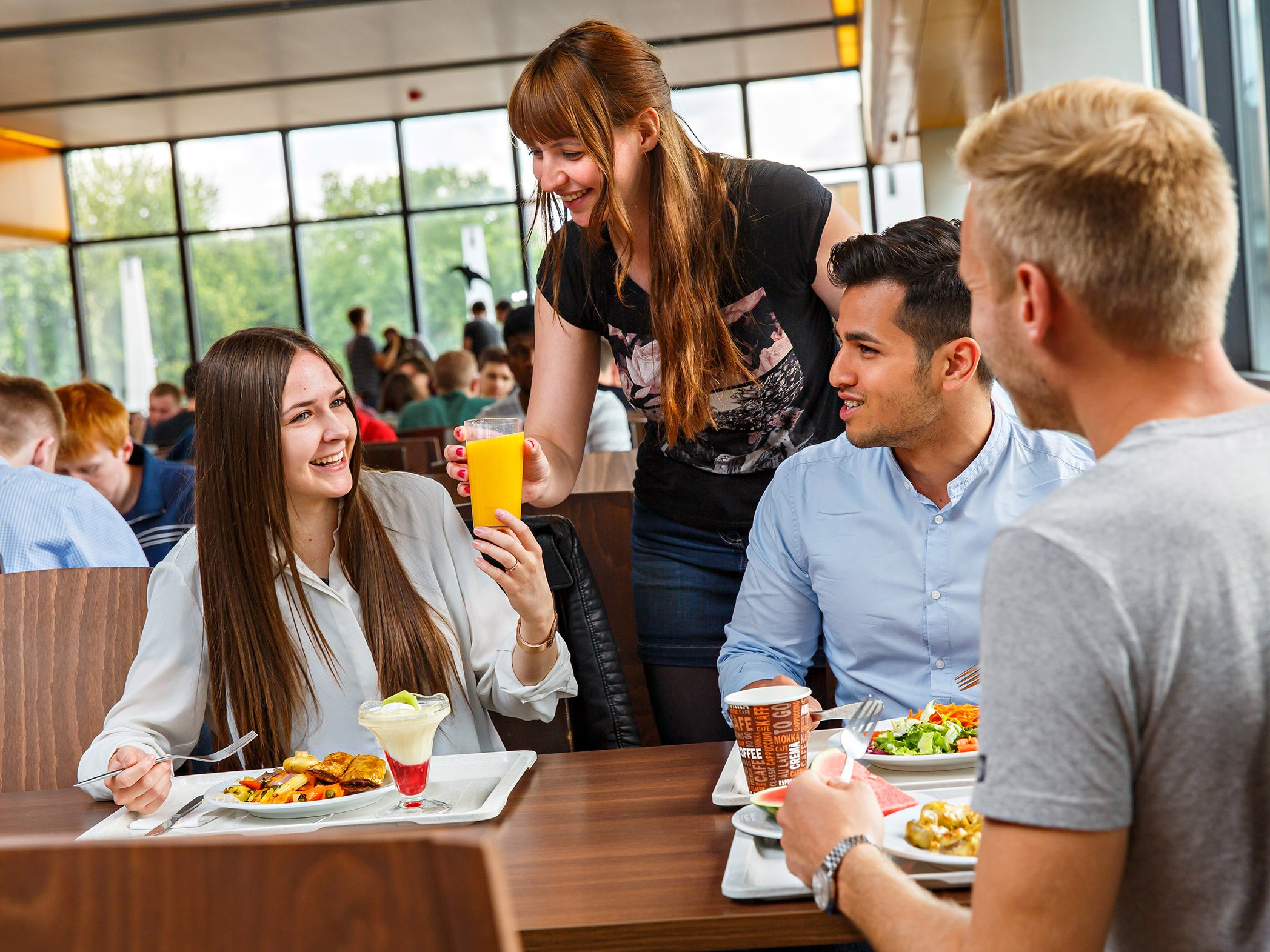 Studierende essen und unterhalten sich in Hauptmensa