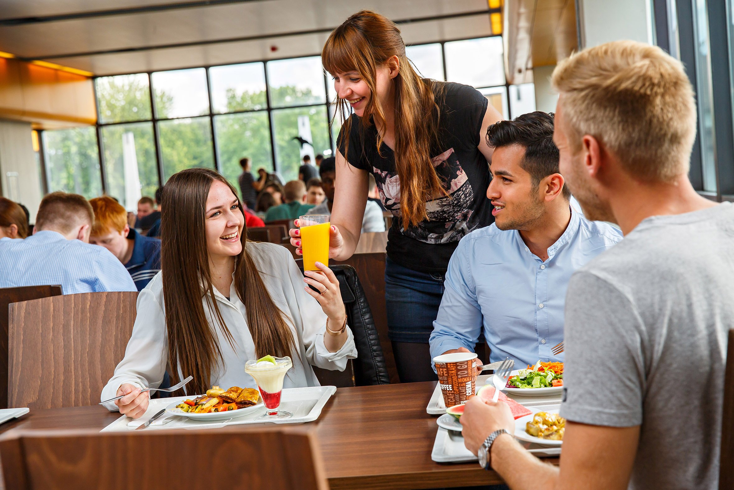 Studierende essen und unterhalten sich in Hauptmensa