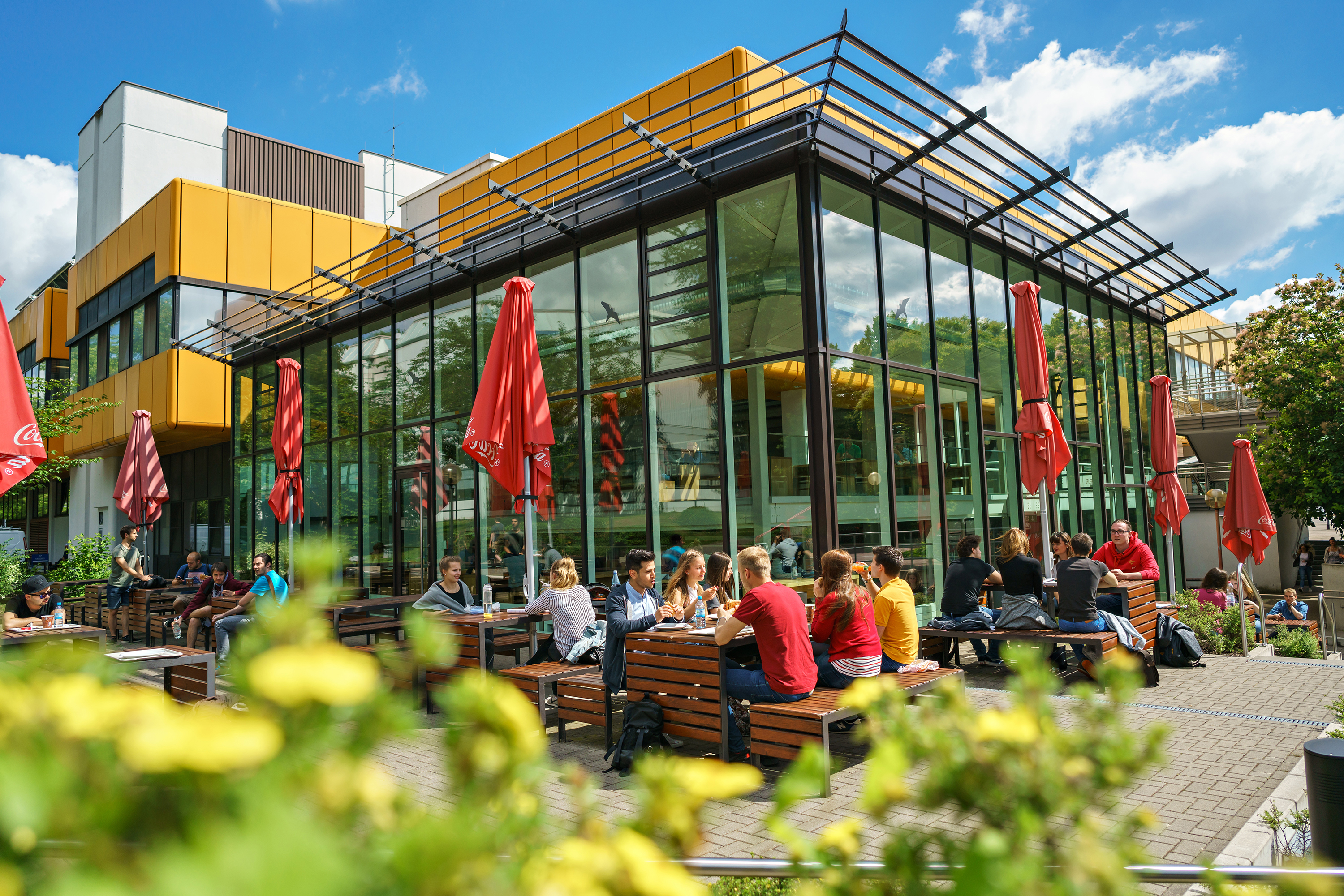 Studierende sitzen an einem Tisch im Außenbereich der Galerie