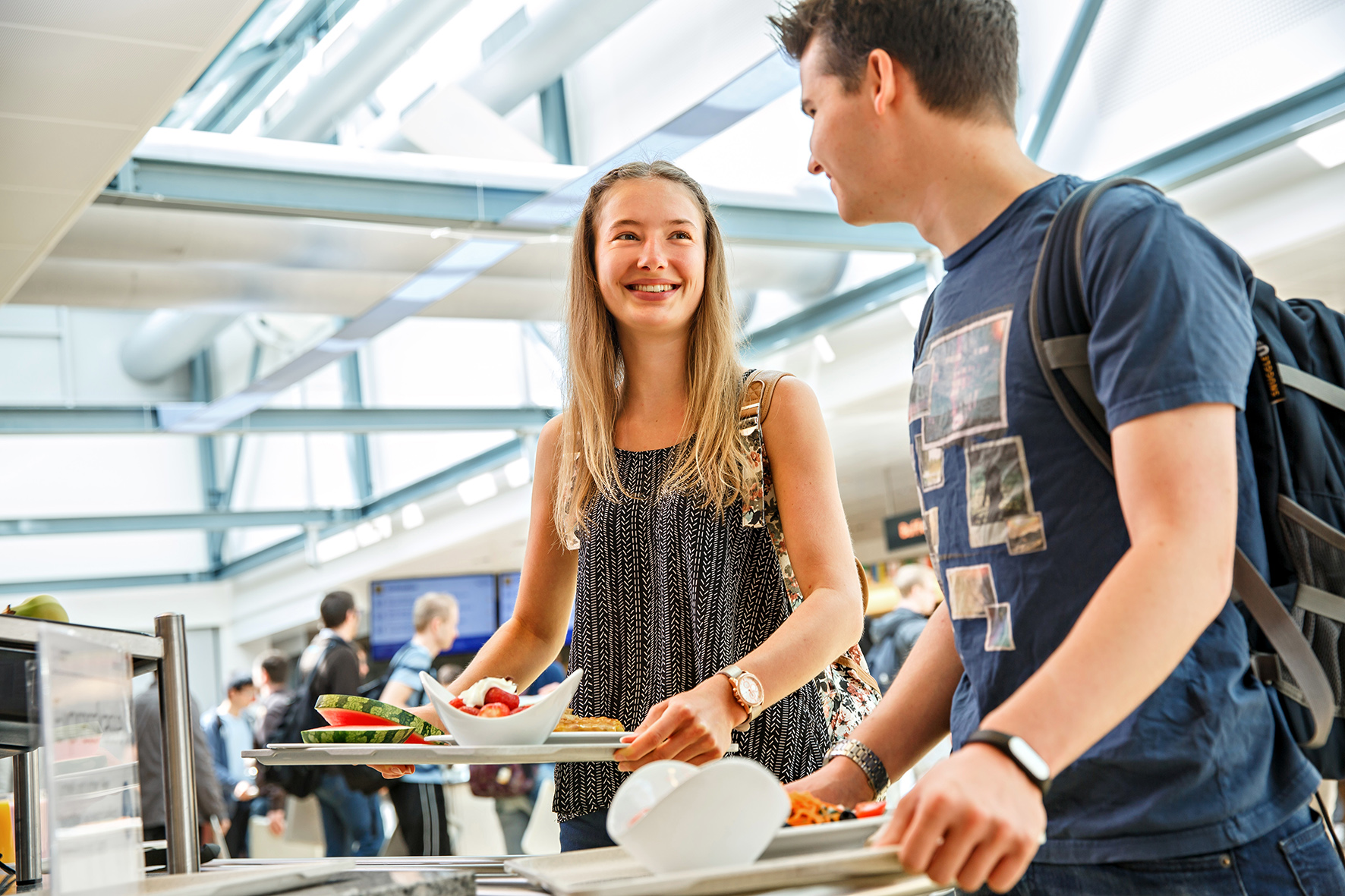 Zwei Studierende unterhalten sich im Ausgabebereich der Hauptmensa