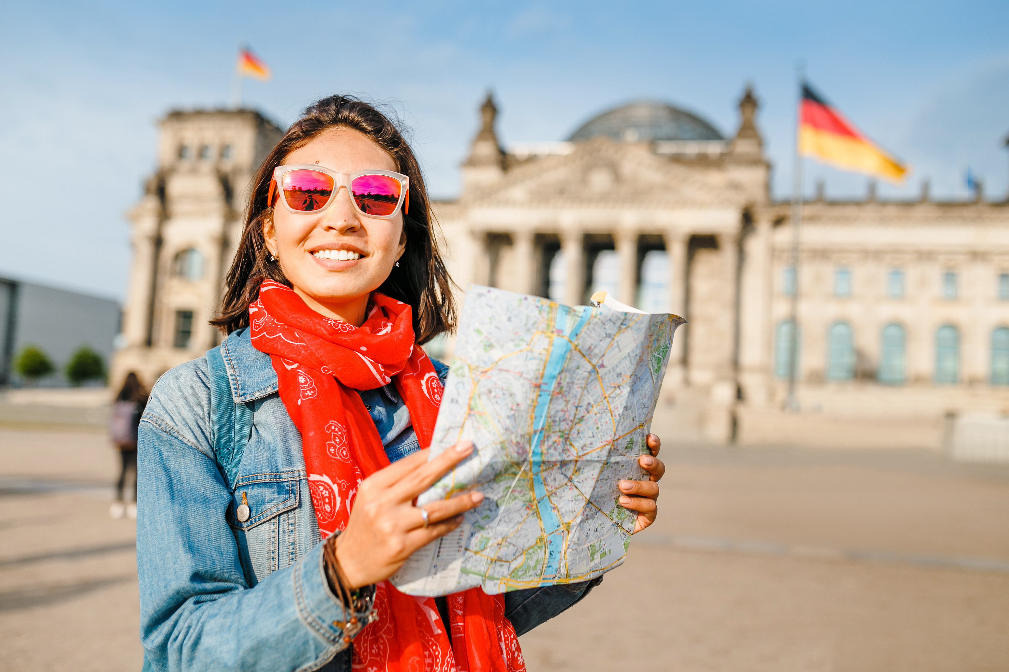 Junge Frau schaut auf einen Stadtplan in Berlin.